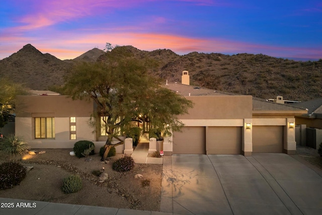 pueblo-style home with a mountain view and a garage