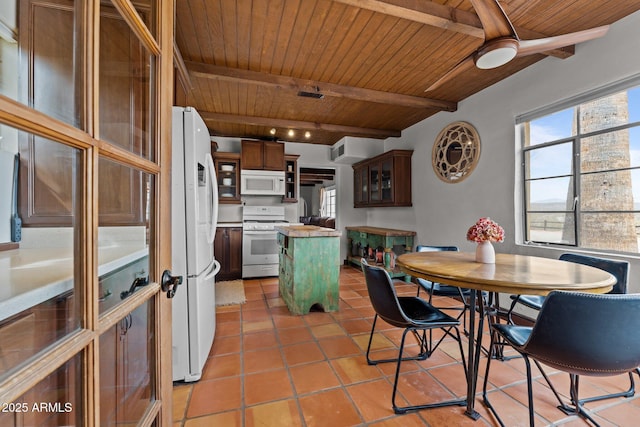 dining space featuring beam ceiling, light tile patterned floors, and wood ceiling