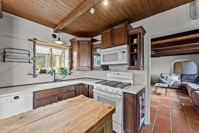 kitchen with white appliances, tile patterned floors, wooden ceiling, and a sink