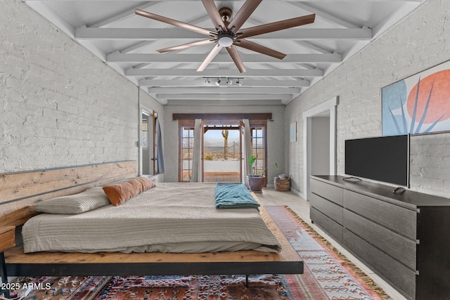 bedroom featuring beam ceiling, brick wall, and access to exterior