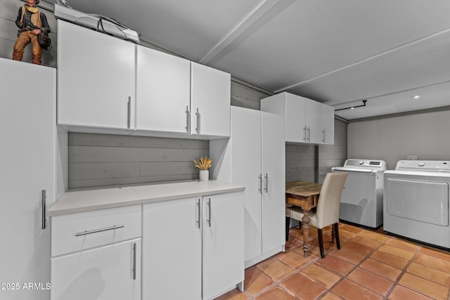 washroom featuring washer and dryer, light tile patterned floors, and cabinet space