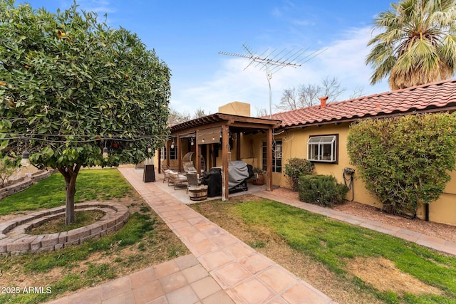 view of front of property with stucco siding, a tile roof, a patio, a front yard, and outdoor lounge area