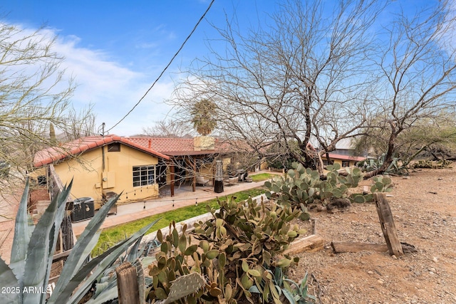 back of house featuring stucco siding, a patio, and a tiled roof