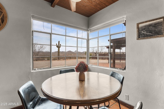 dining area with wooden ceiling and a textured wall