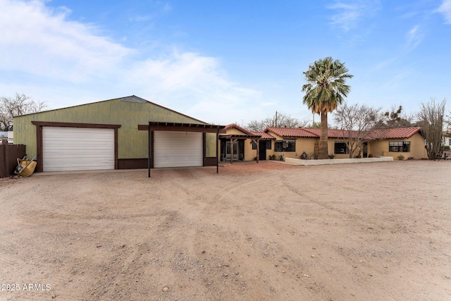 ranch-style house featuring a tiled roof, stucco siding, and driveway