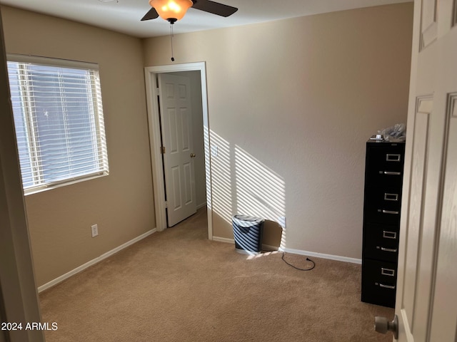 interior space with ceiling fan and light carpet