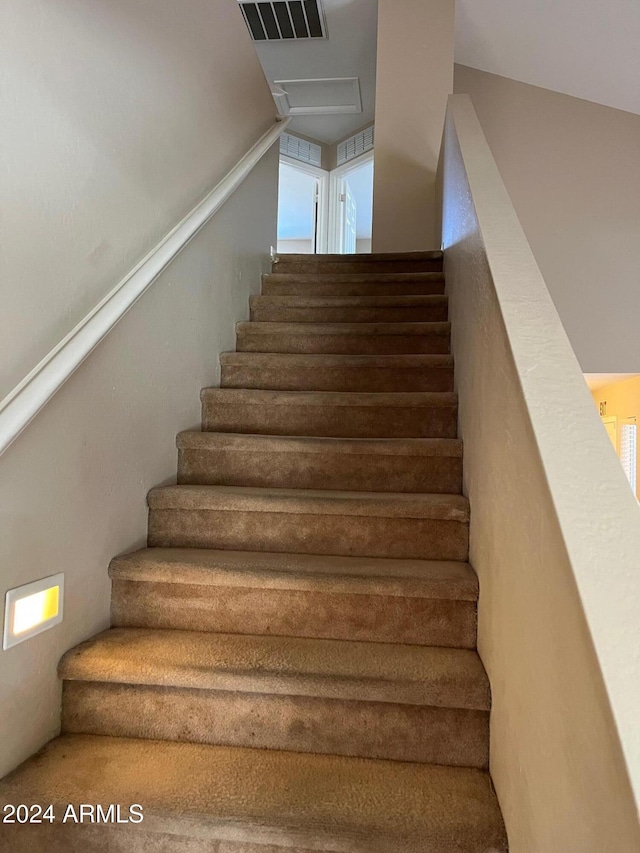 staircase with lofted ceiling