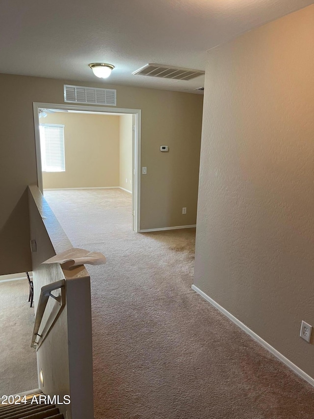 hall featuring light colored carpet