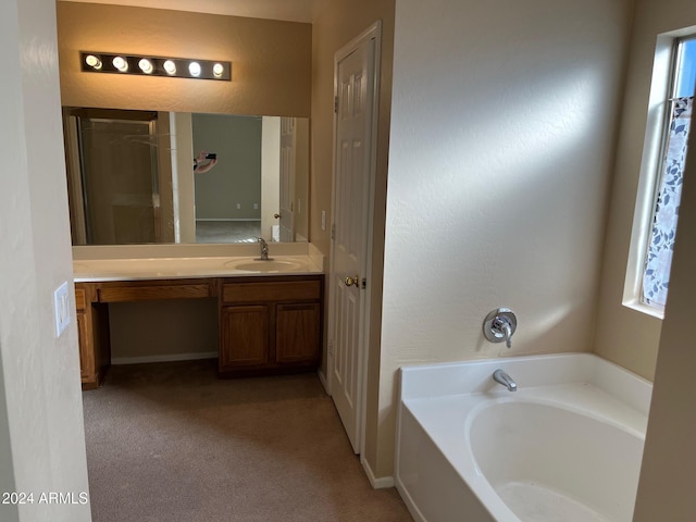 bathroom featuring a wealth of natural light, vanity, and a bathtub