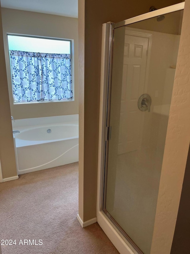 bathroom featuring shower with separate bathtub