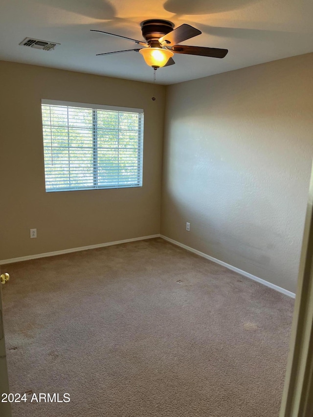 carpeted spare room with ceiling fan