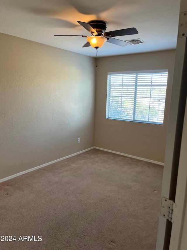 carpeted empty room featuring ceiling fan