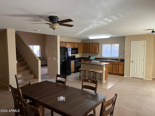 carpeted dining area featuring ceiling fan and sink