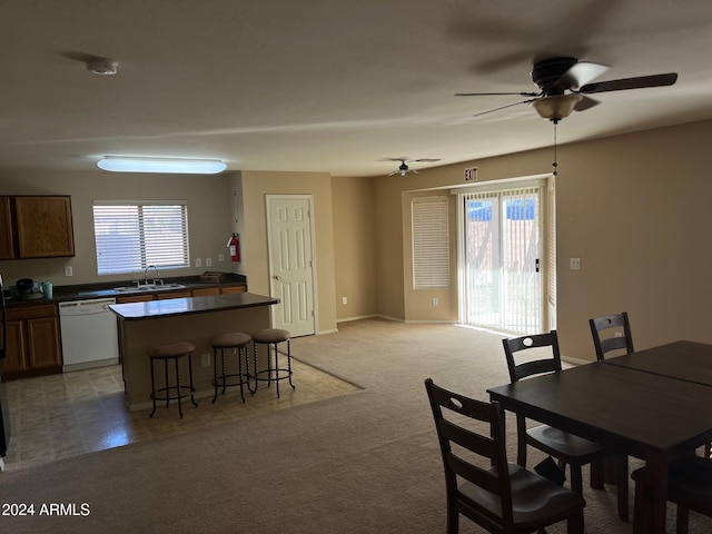 dining area featuring light carpet, sink, a wealth of natural light, and ceiling fan