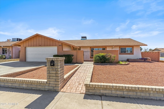 single story home featuring a fenced front yard, driveway, an attached garage, and brick siding