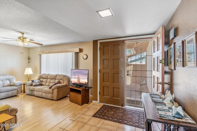 interior space with a wealth of natural light, a textured ceiling, wood finished floors, and a ceiling fan