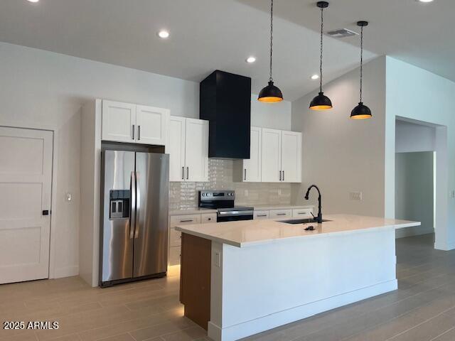 kitchen with stainless steel appliances, visible vents, decorative backsplash, white cabinetry, and a sink