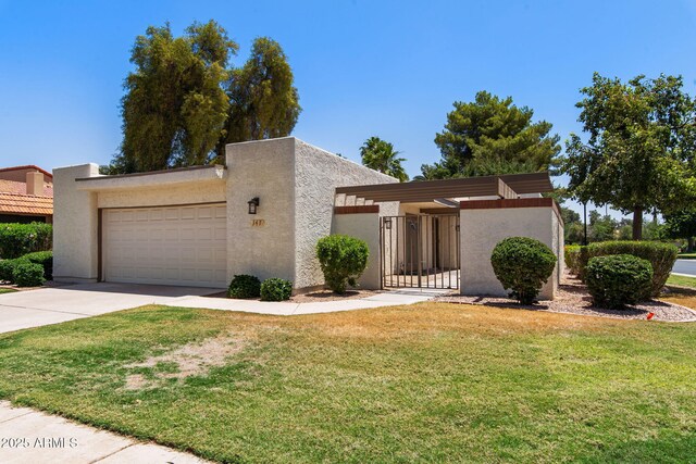 347 Leisure World, Mesa, AZ 85206 - view of front of home featuring a garage, concrete driveway, a gate, and stucco siding