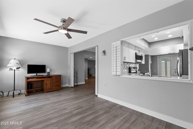 347 Leisure World, Mesa, AZ 85206 - unfurnished living room featuring ceiling fan, light wood-style floors, and baseboards