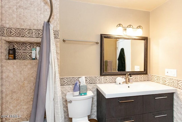 bathroom featuring vanity, curtained shower, toilet, and tile walls