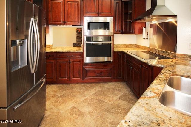 kitchen featuring wall chimney exhaust hood, stainless steel appliances, sink, and light stone counters