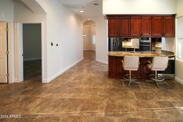 kitchen featuring stainless steel appliances, a breakfast bar, sink, and kitchen peninsula