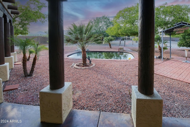 yard at dusk with a fenced in pool and a patio