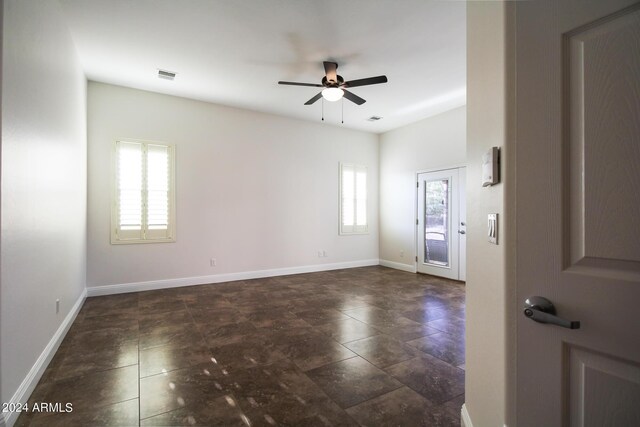 spare room featuring ceiling fan and plenty of natural light