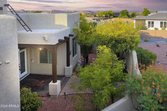 back house at dusk featuring a patio area