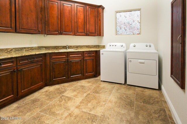 washroom featuring sink, cabinets, and independent washer and dryer