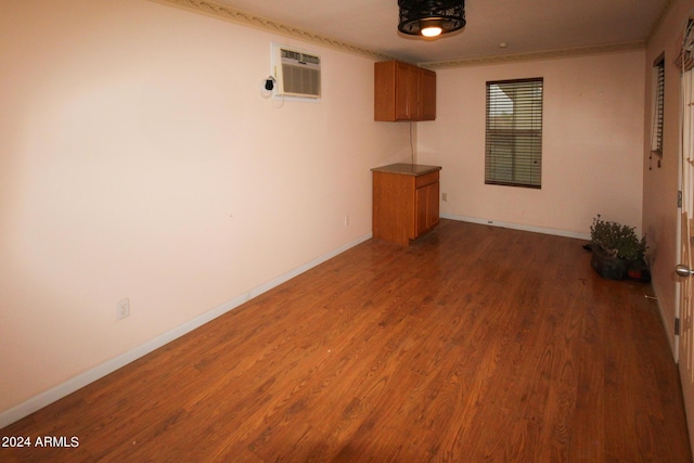 spare room featuring a wall unit AC and dark hardwood / wood-style flooring