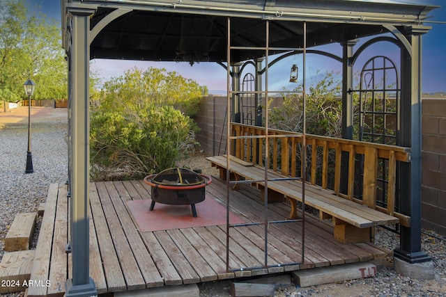 deck at dusk with a gazebo and an outdoor fire pit