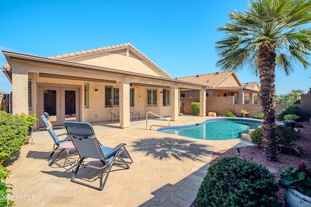 view of swimming pool with a patio area, a fenced backyard, a fenced in pool, and french doors