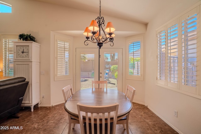 dining room featuring lofted ceiling, dark tile patterned floors, a chandelier, and baseboards