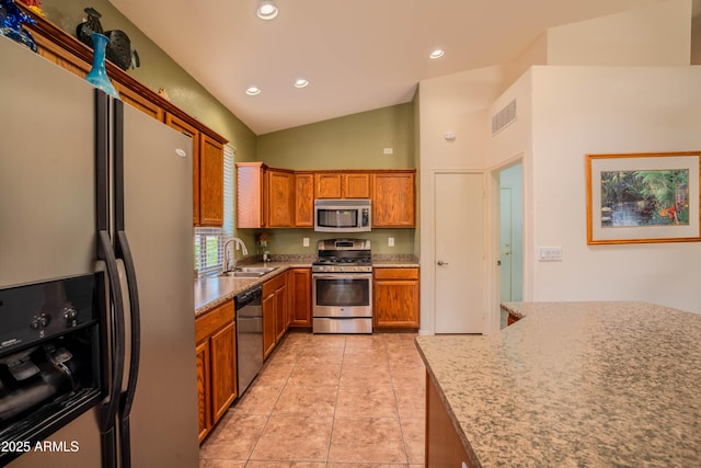 kitchen featuring recessed lighting, visible vents, appliances with stainless steel finishes, brown cabinetry, and a sink