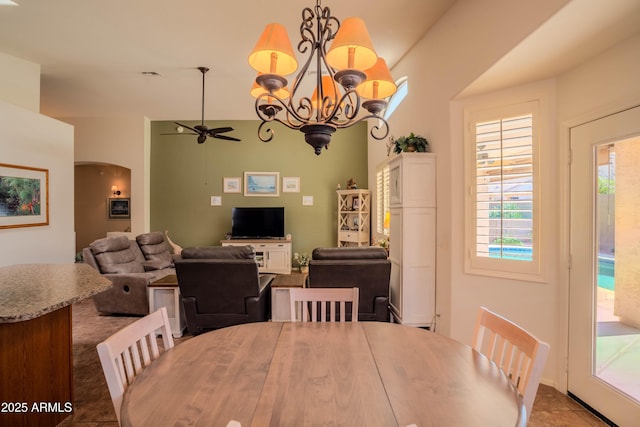 dining room featuring arched walkways and ceiling fan with notable chandelier