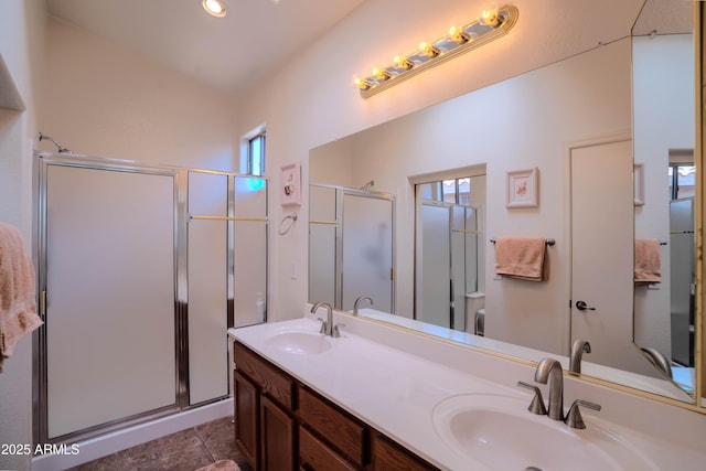 full bath featuring a stall shower, a sink, and tile patterned floors