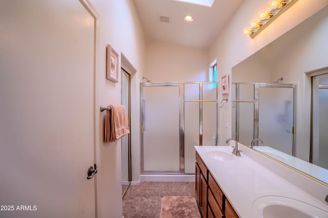 full bath with double vanity, a stall shower, and a sink