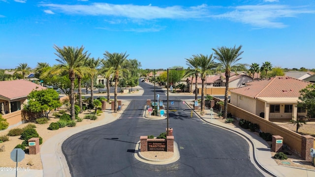 view of road featuring curbs, a gated entry, a gate, and a residential view