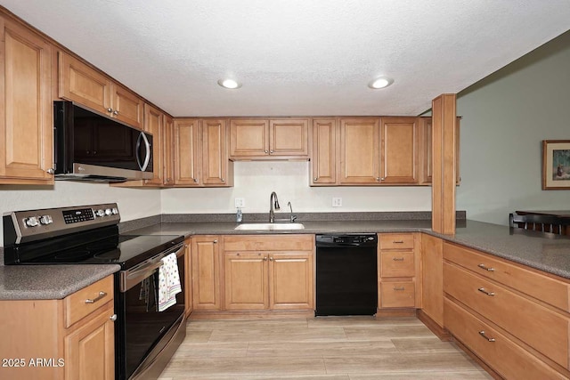 kitchen featuring stainless steel appliances, sink, and a textured ceiling