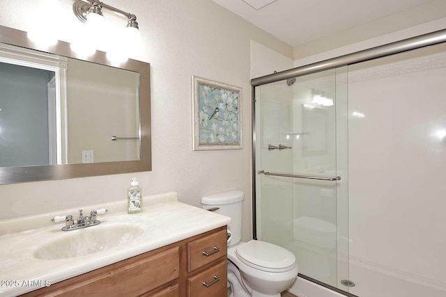 bathroom with walk in shower, vanity, and toilet