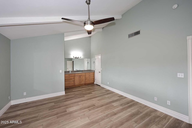 unfurnished bedroom with hardwood / wood-style flooring, beamed ceiling, high vaulted ceiling, and ceiling fan