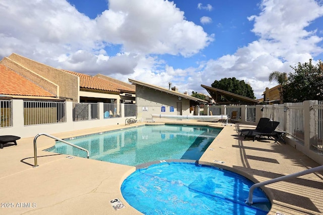 view of swimming pool with a hot tub and a patio area