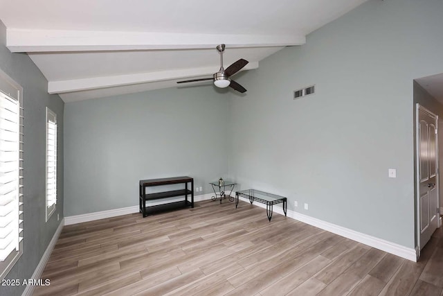 empty room featuring ceiling fan, vaulted ceiling with beams, and light hardwood / wood-style floors