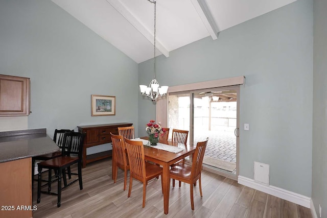 dining area featuring beam ceiling, light hardwood / wood-style flooring, high vaulted ceiling, and a chandelier