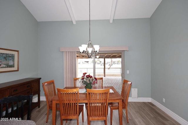 dining space with beam ceiling, wood-type flooring, and a chandelier