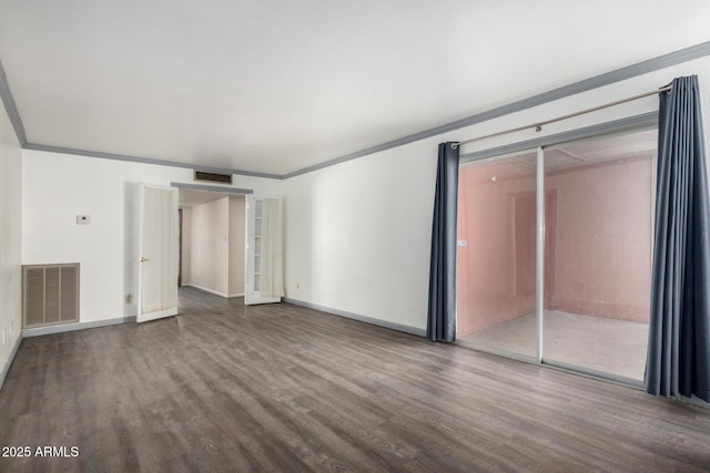 empty room with visible vents, wood finished floors, and ornamental molding