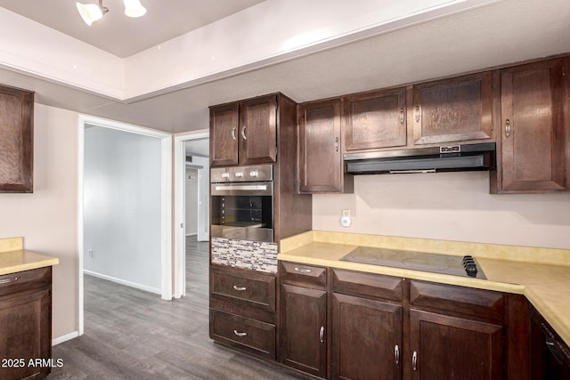 kitchen with light countertops, dark brown cabinetry, stainless steel oven, and under cabinet range hood