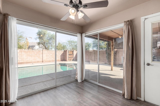 unfurnished sunroom featuring ceiling fan