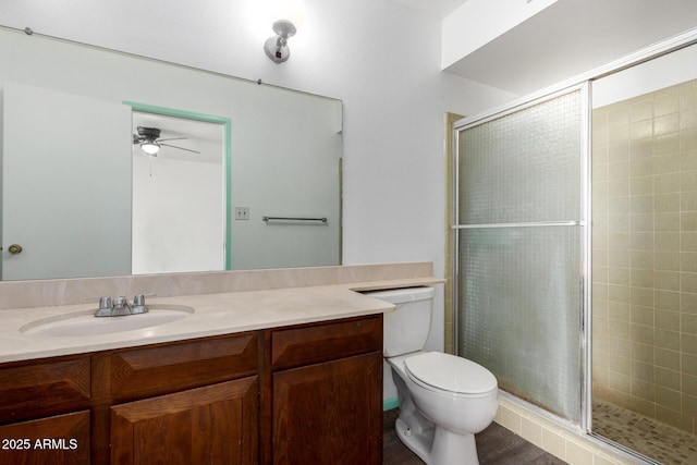 bathroom featuring a shower stall, toilet, and vanity